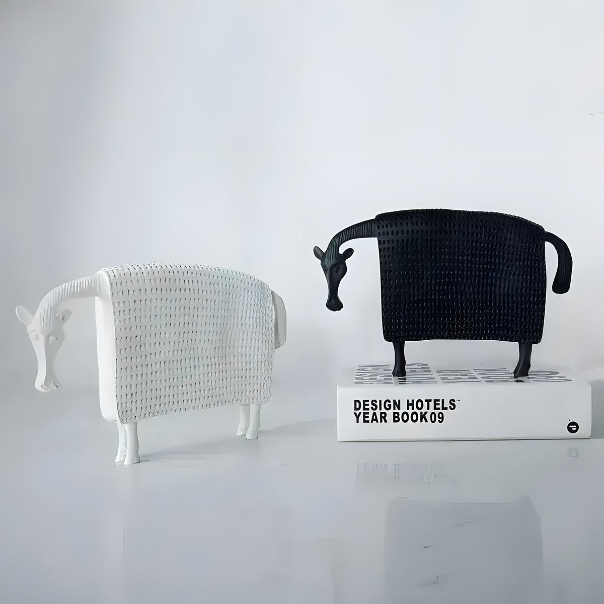 Pair of winter horse sculptures in white and black woven texture finish, standing on marble surface, front view