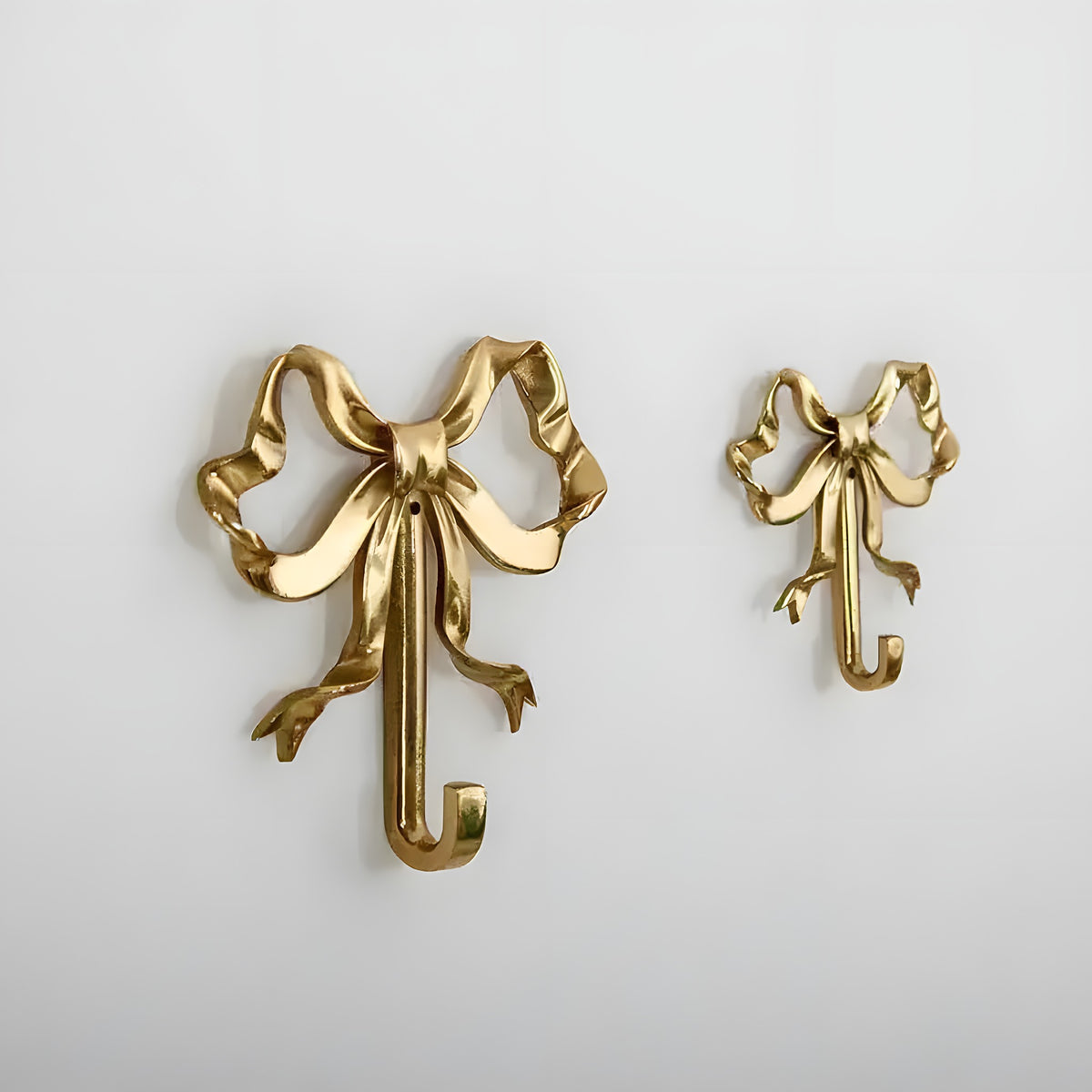 French Retro Bow Shape Brass Wall Hook in gold, two sizes shown side by side on white wall, ornate ribbon bow with hook
