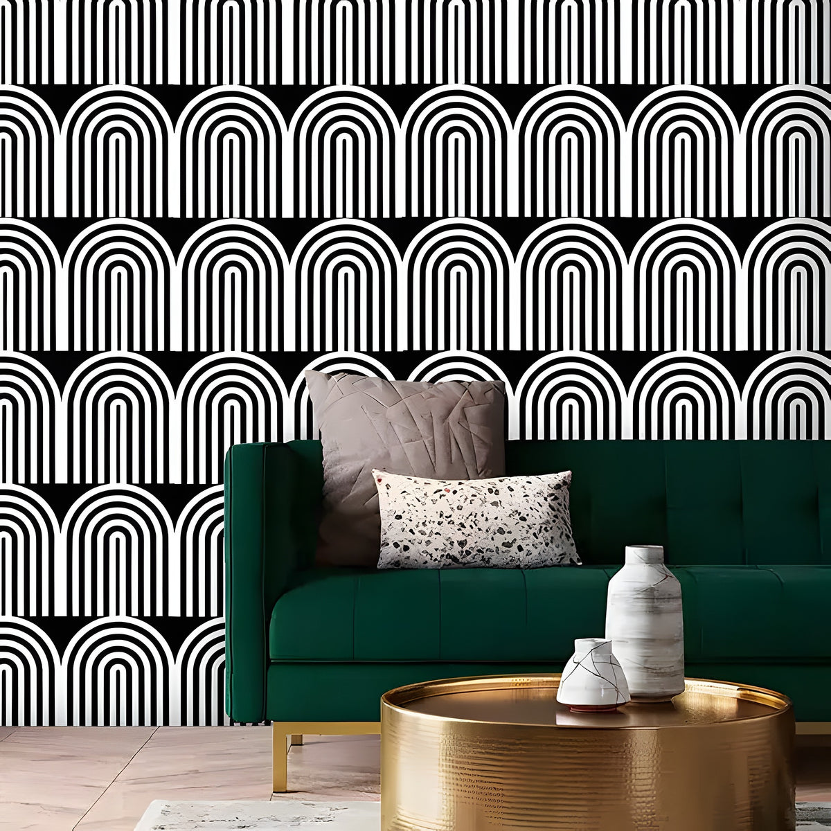 Green sofa with decorative pillows against a black and white geometric patterned wall.