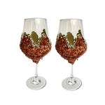 Pair of red quartz wine glasses, clear stemware, ruby-red quartz chips covering lower bowl, gold rim accent