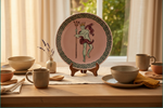 A decorative ceramic plate displayed on a wooden table stand, surrounded by matching beige ceramic bowls, mugs, and plates in a warm, sunlit dining setting.
