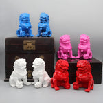 Colorful lion statues on a wooden chest against a gray background