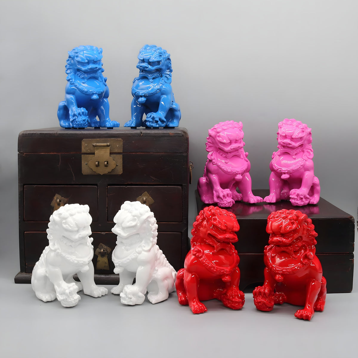 Colorful lion statues on a wooden chest against a gray background