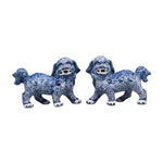 Two blue and white ceramic lion dog figurines on a gray background