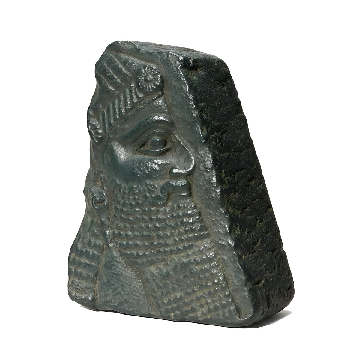 Stone sculpture of a face with intricate details on a plain background