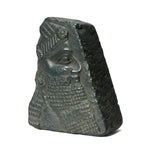 Stone sculpture of a face with intricate details on a plain background