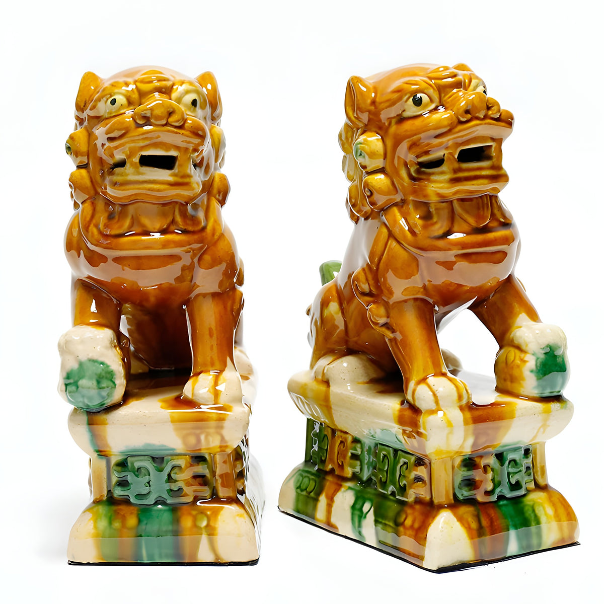 Pair of ceramic lion statues on a white background