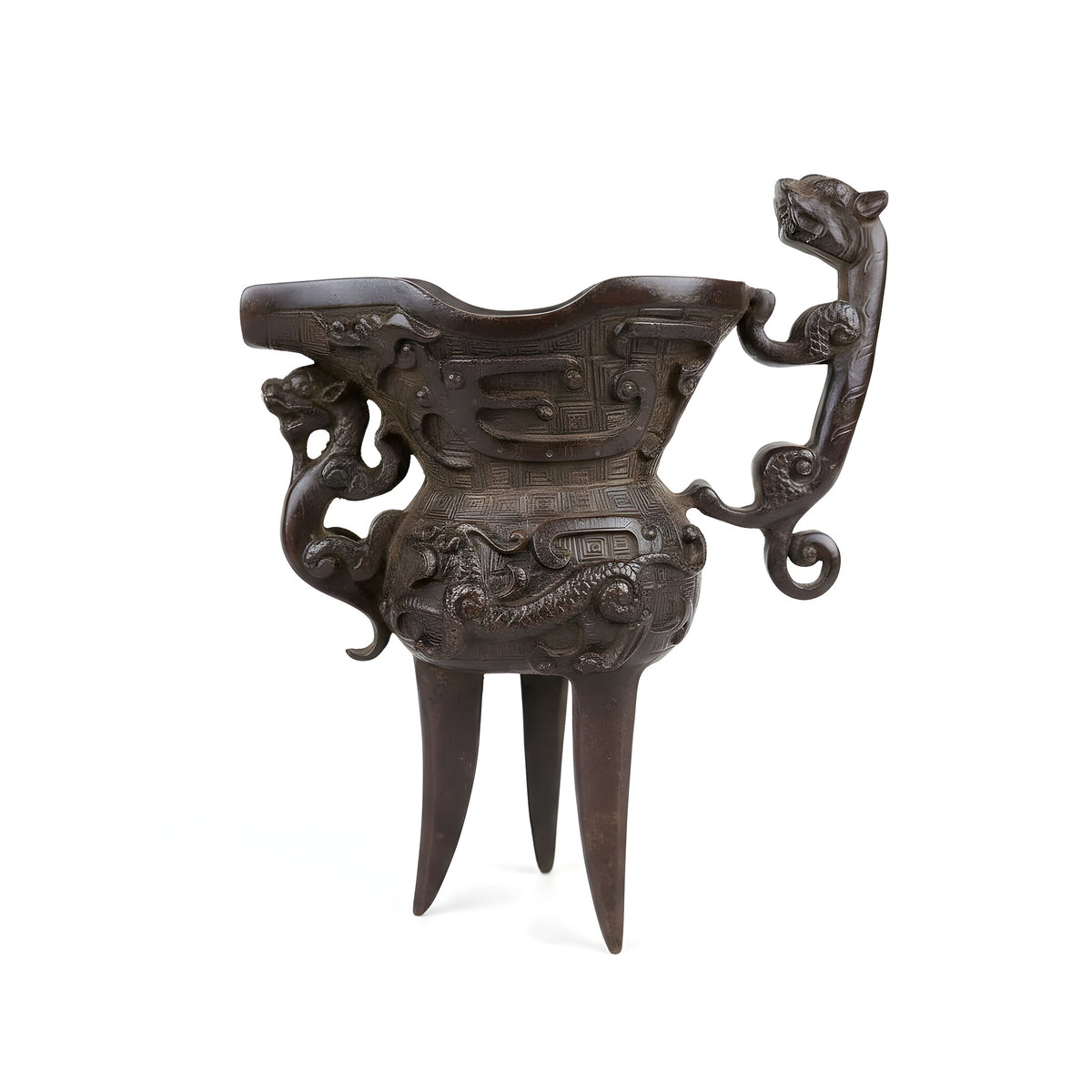 Hand holding a intricately carved wooden object with detailed carvings on a wooden surface.