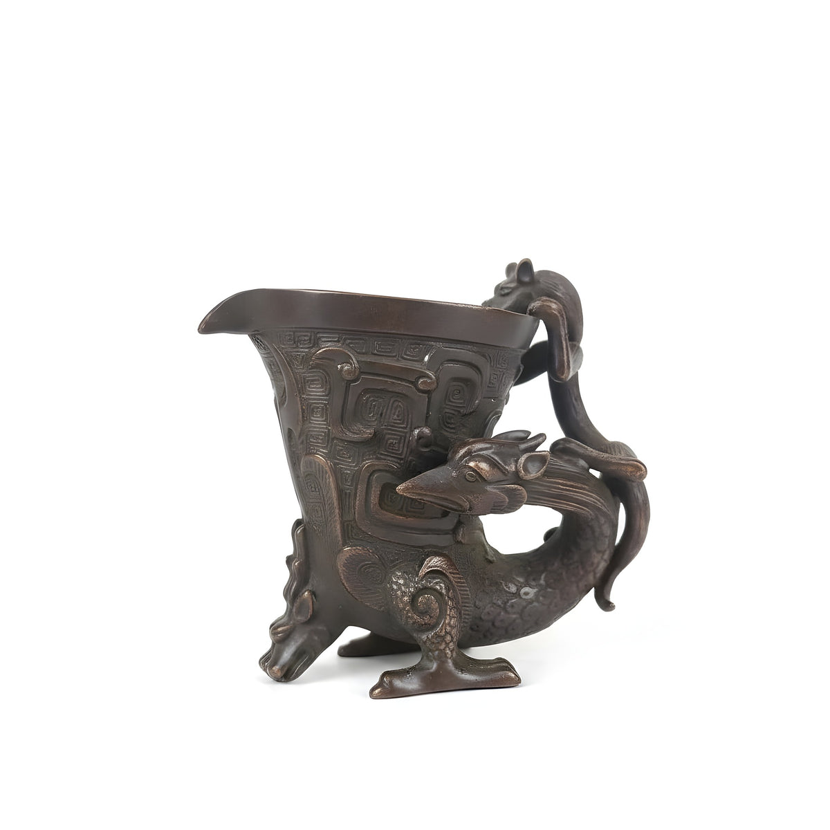 Bronze cup with dragon design on a wooden surface
