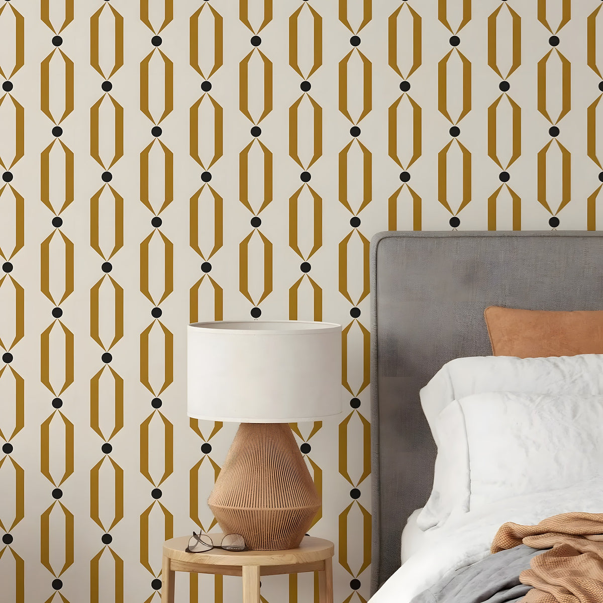 Bedroom with geometric patterned wallpaper, bed, and lamp.