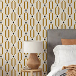 Bedroom with geometric patterned wallpaper, bed, and lamp.