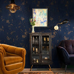 Living room with dark blue floral wallpaper, orange sofa, and decorative cabinet.