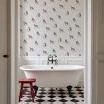 Bathroom with a freestanding bathtub, red stool, and patterned wallpaper.