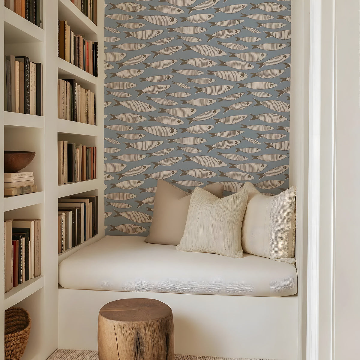 Nook with bookshelf, cushioned seat, and fish-patterned wallpaper