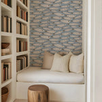 Nook with bookshelf, cushioned seat, and fish-patterned wallpaper