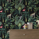 Jungle-themed wallpaper with animals and plants on a black background, displayed in a room with a wooden dresser.