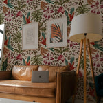 Living room with a brown leather sofa, floral-patterned wall, and a lamp.