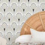 Wicker chair against a decorative wall with geometric pattern