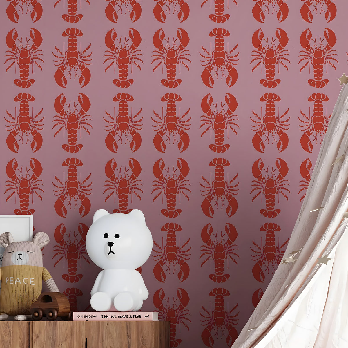 White teddy bear on a wooden shelf against a pink wall with red lobster pattern