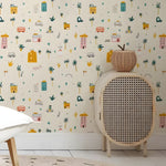 Wicker chair with patterned wallpaper featuring colorful illustrations of buildings and nature.