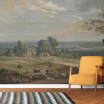Yellow armchair in front of a large landscape painting on a wall.
