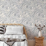 Bedroom with floral wallpaper, bed, and side table.
