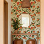 Room interior with peach-themed wallpaper, round mirror, and brown stools.
