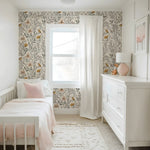Children's bedroom with floral wallpaper, white furniture, and pink accents.