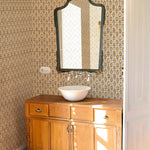 Wooden vanity with a mirror against patterned wallpaper