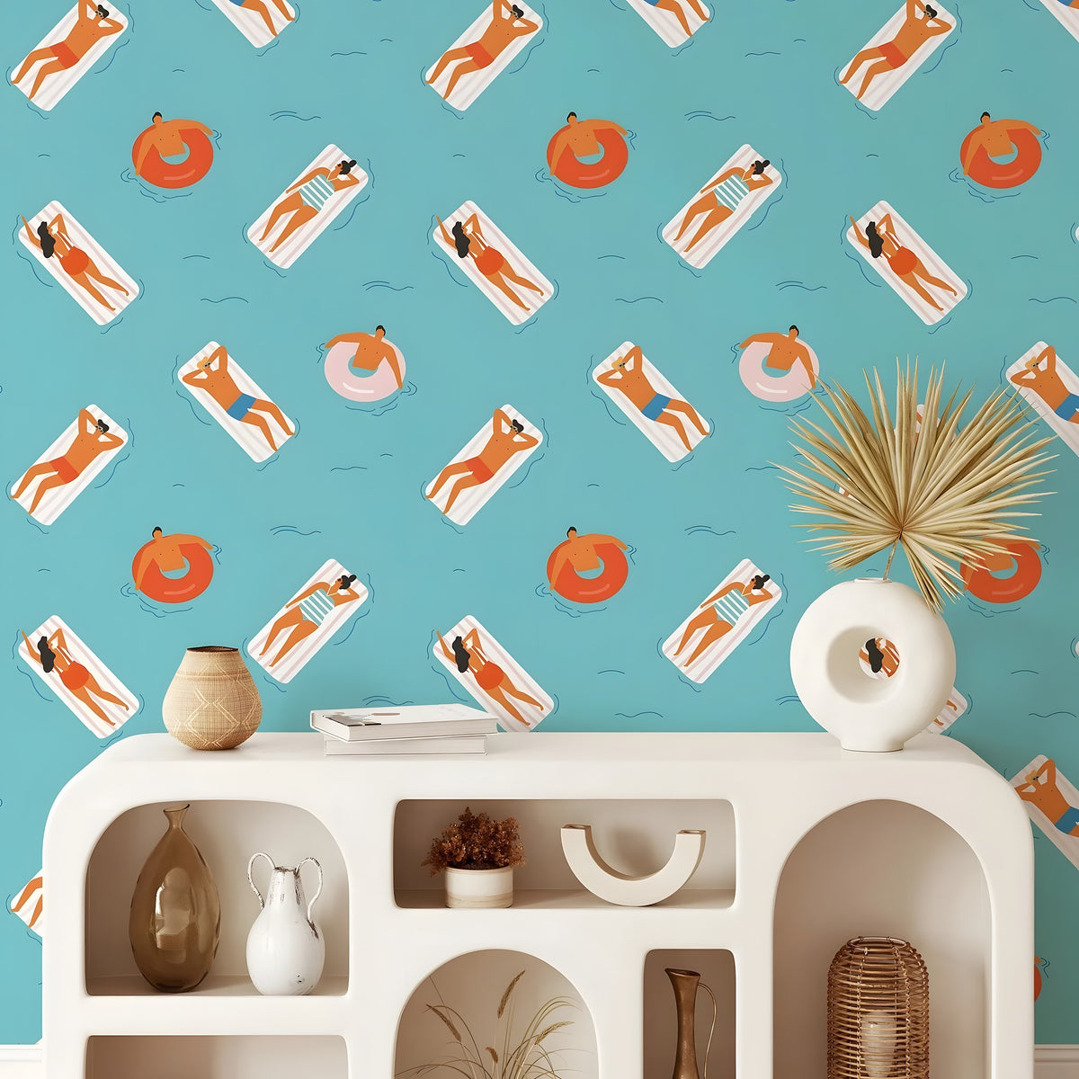Wallpaper with beach-themed design featuring people on lounge chairs and pool floats, displayed in a room with a shelf.