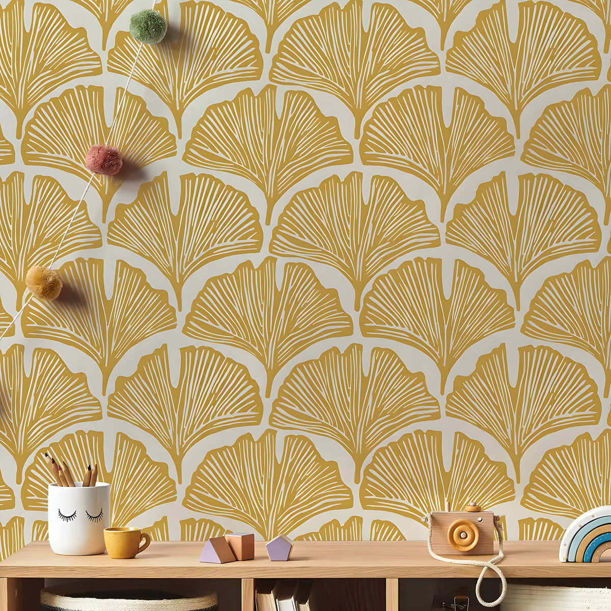 Wallpaper with a gold leaf pattern on a wall with a wooden shelf below.