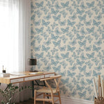 Wallpaper with butterfly pattern in a room with a desk and chair.