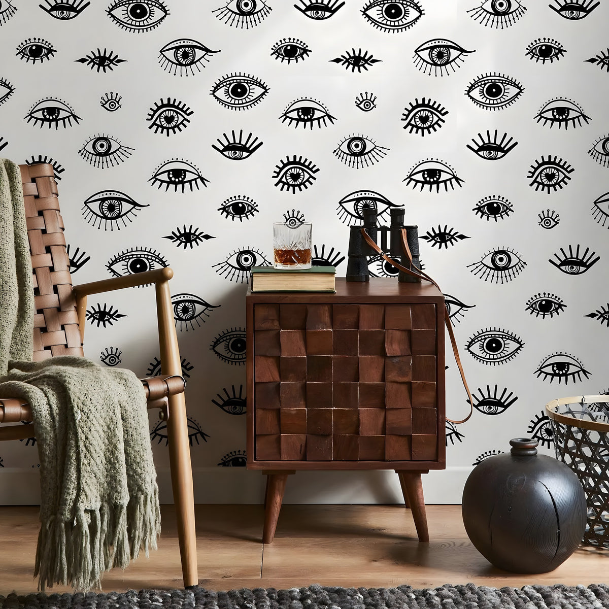 Room interior with wooden cabinet, chair, and decorative items against a wall with eye pattern.