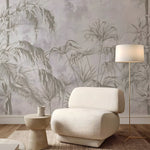 Beige armchair in a room with tropical leaf wallpaper and a floor lamp.