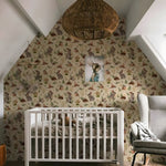 Nursery room with crib, patterned wallpaper, and framed picture.