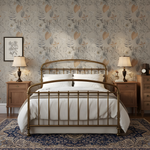 Bedroom with a gold bed frame, white bedding, and floral wallpaper.