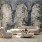 Modern living room with beige sofa, armchair, and decorative table against a tropical wall mural.