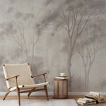 Woven chair and side table against a forest mural wall.