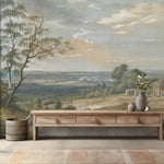 Wooden console table with decorative items against a scenic wall mural
