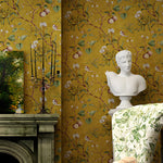 Decorative interior with floral wallpaper, white bust, and green floral chair.