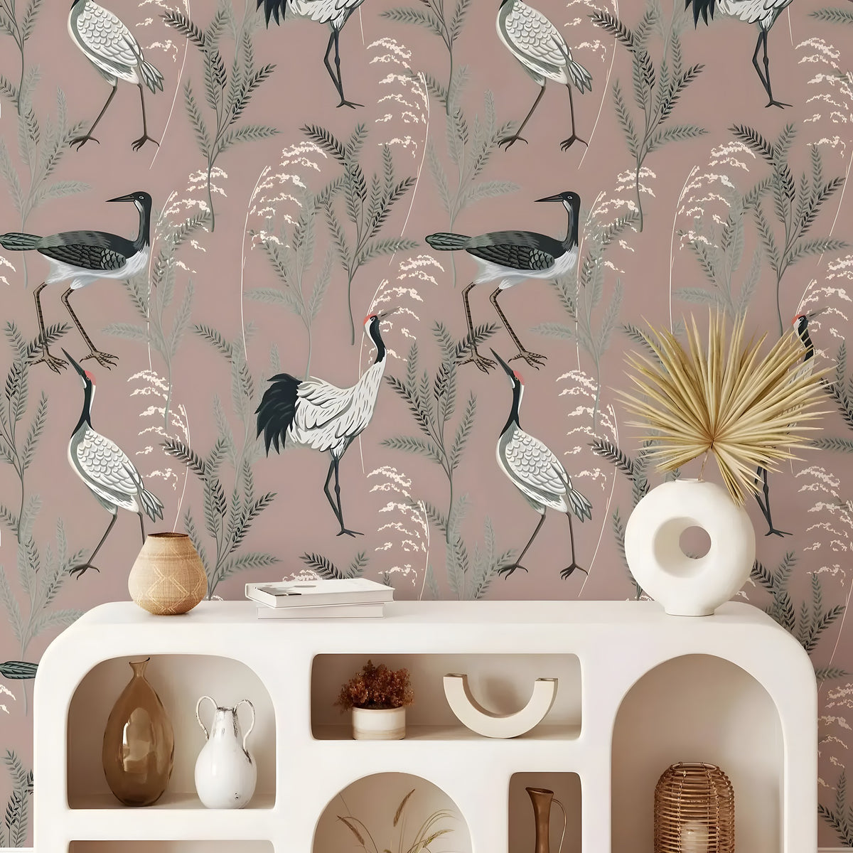 Decorative wallpaper with birds and plants on a pink background, featuring a white console table with decorative items.