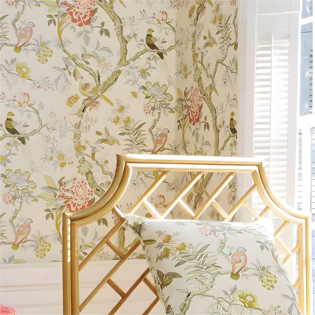 Floral wallpaper with birds and a gold headboard in a room.