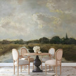 Dining area with a table and chairs against a scenic wall mural.