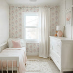 Children's bedroom with pink and white theme, including a bed, dresser, and decorative elements.