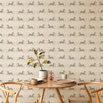Dining table with chairs against a wallpapered wall featuring horse patterns.