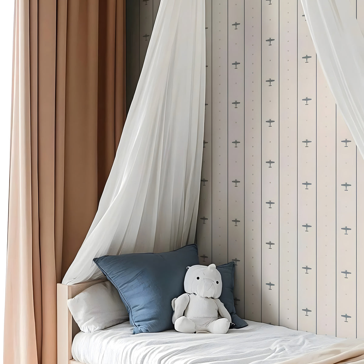Children's bed with canopy, pillows, and a teddy bear against a patterned wall.