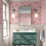 Bathroom with pink wallpaper featuring people in swimsuits, a green vanity, and a mirror.