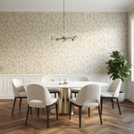Dining room with a round table and white chairs against a patterned wall.