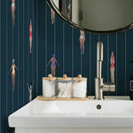 Bathroom sink with decorative items against a wall with vertical line pattern and small figures.