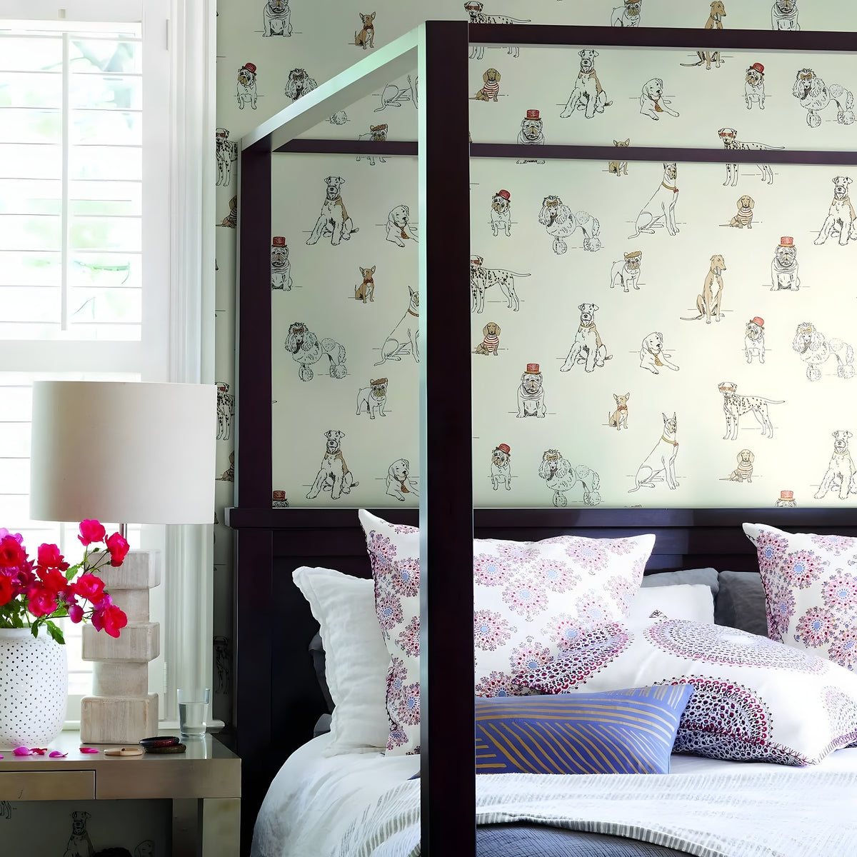 Bedroom with a bed featuring patterned headboard and pillows, next to a window with blinds.